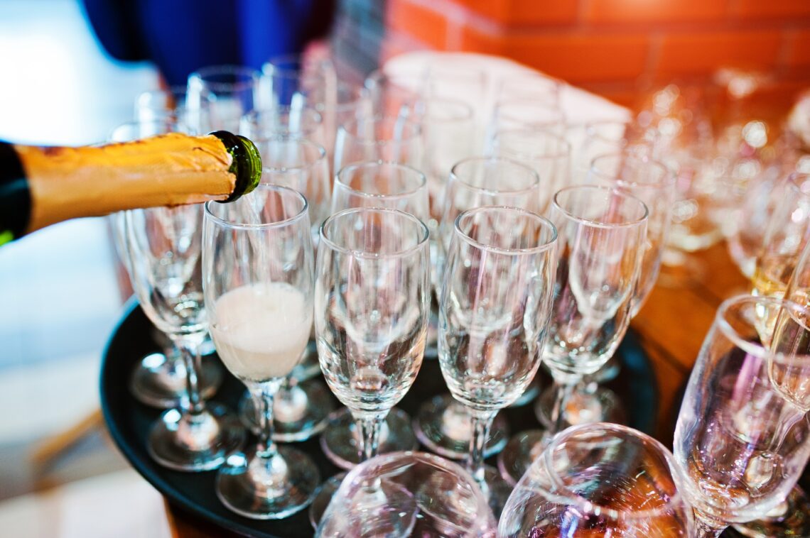 Pour champagne into glasses at wedding party